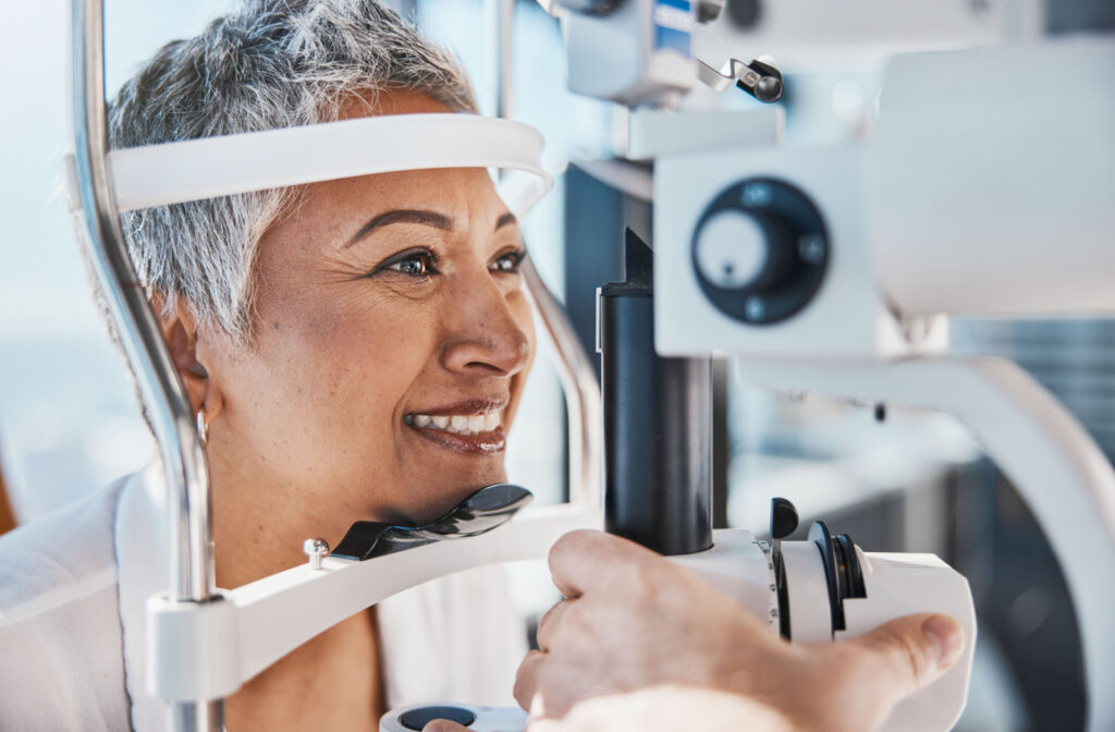 A smiling senior woman getting an eye exam from her optometrist.