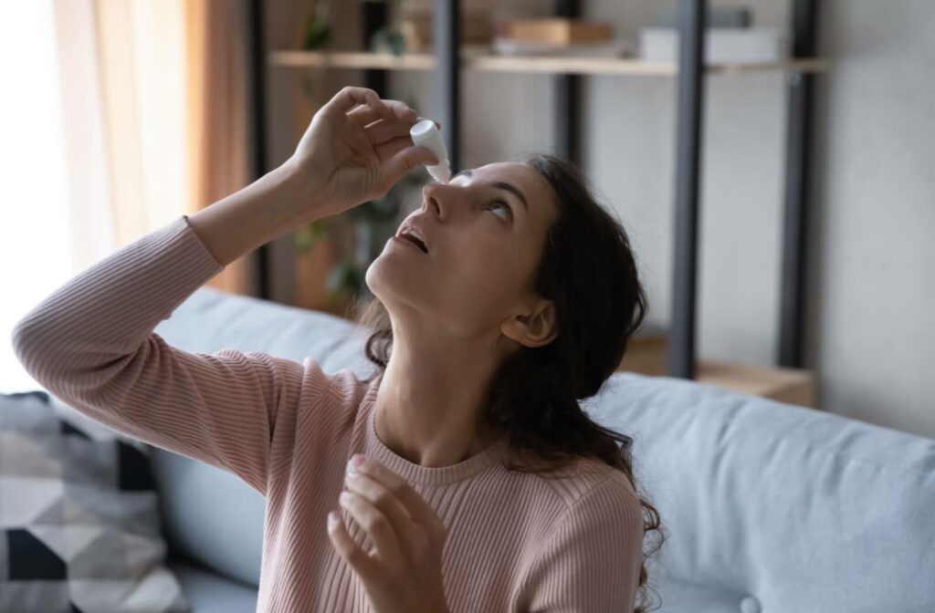 A young woman using eye drops to relieve the symptoms of her dry eye.