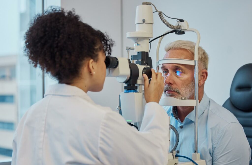 A female optometrist examining a male patient's eyes to diagnose dry eye disease.