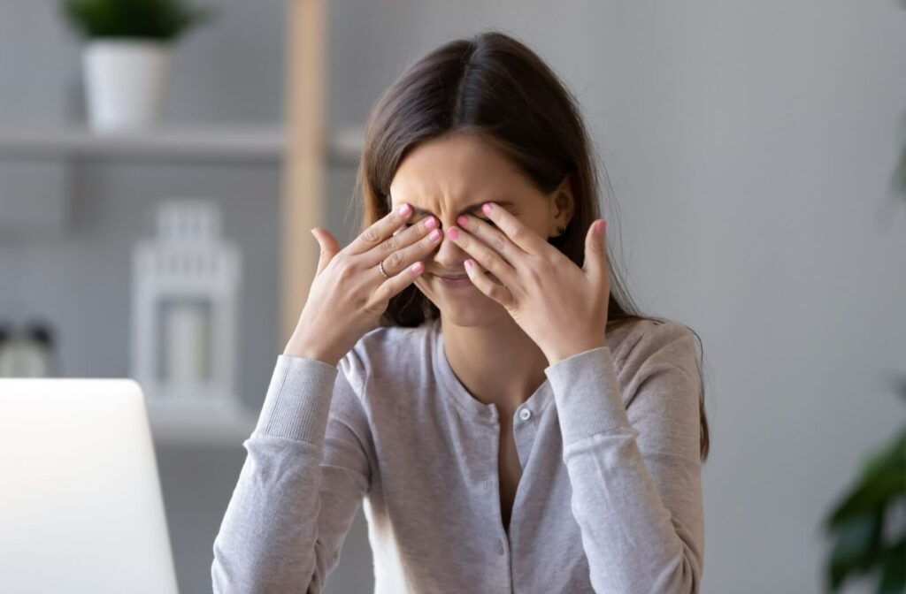 A young woman rubbing her eyes in frustration due to dry eyes.