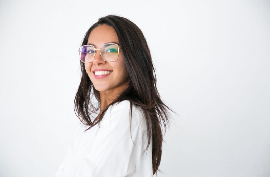 Young woman adjusting her eyeglasses, showing proper frame positioning for clear and comfortable vision.