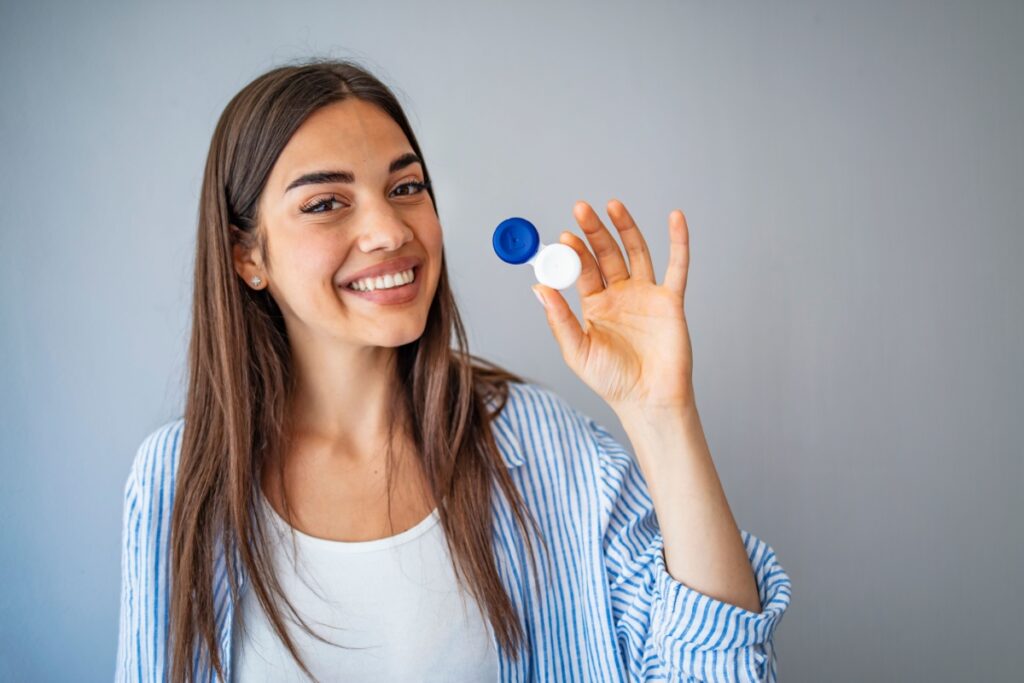 Happy woman displaying contact lens storage case for daily disposable lenses.