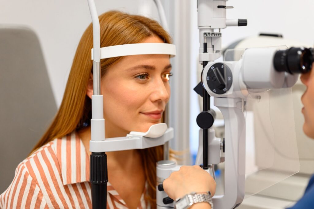 Young woman having comprehensive eye examination with slit lamp at optometry office.