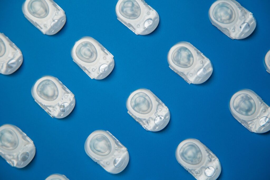 Contact lens blister packs aligned diagonally on a blue background.